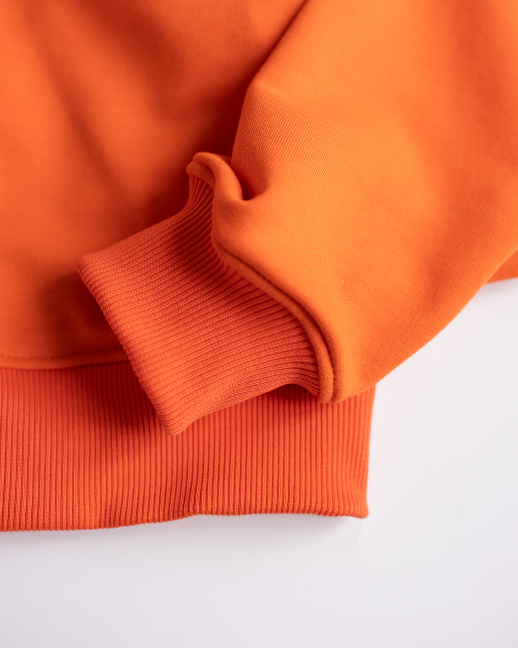 Cuffed sleeve and ribbed hem of orange hoodie for girls