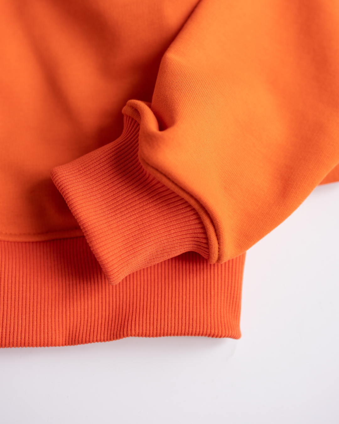 Cuffed sleeve and ribbed hem of orange hoodie for girls