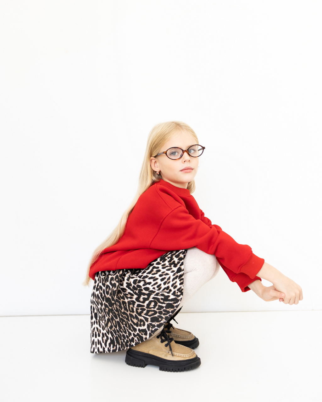 Side view of Alwair Kids leopard skirt in squatting pose