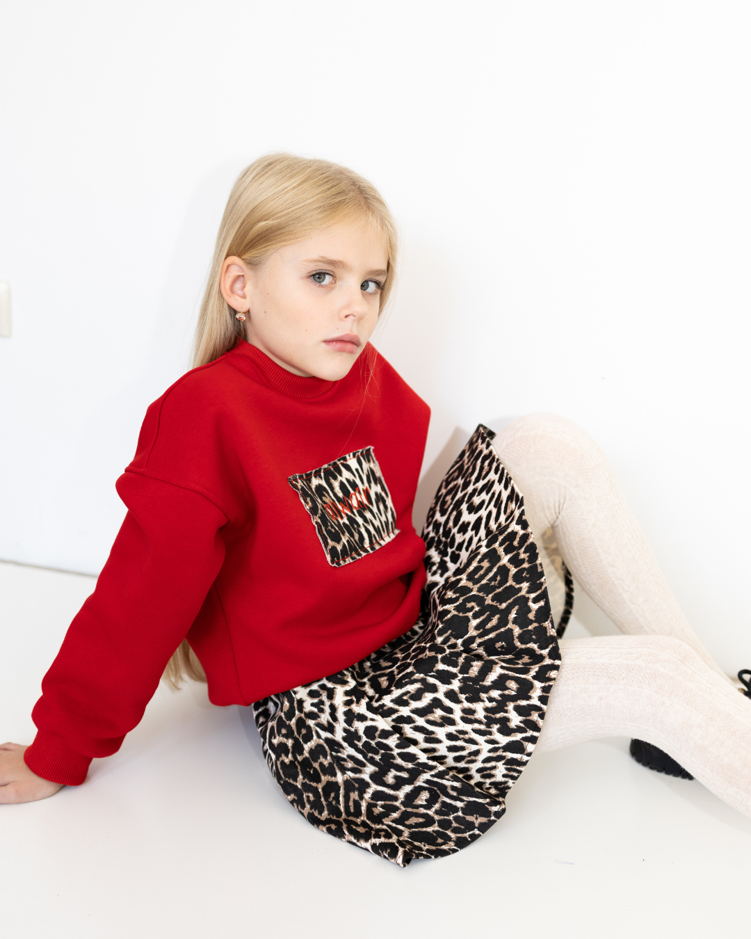 Close-up of Alwair Kids skirt with leopard print while seated