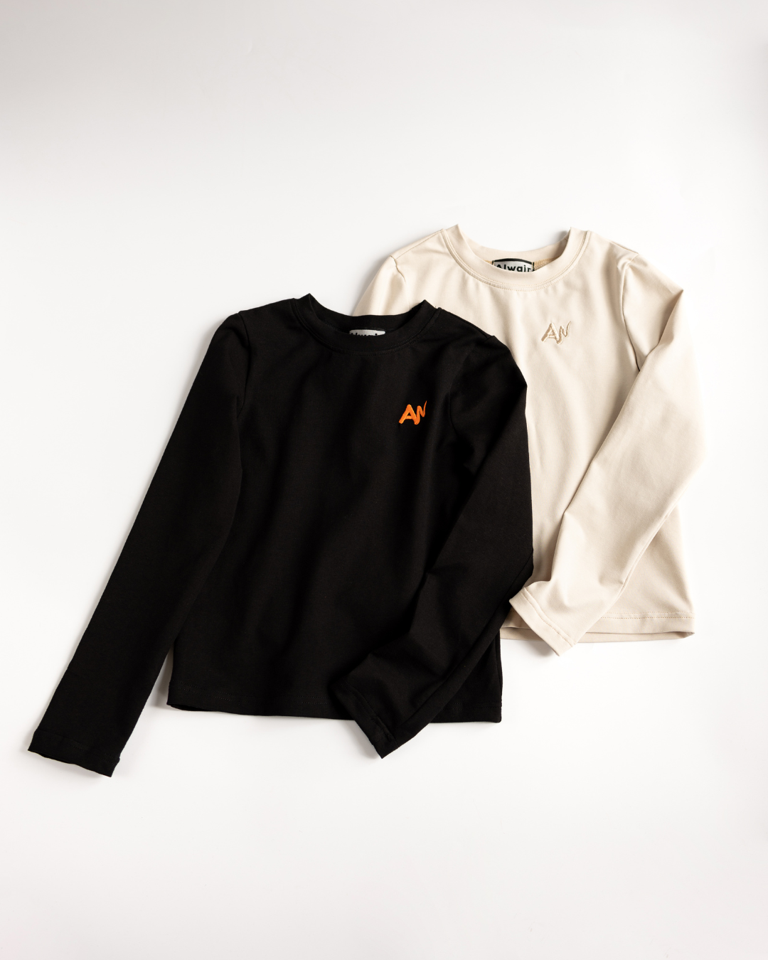 Flat lay of black and beige girls cotton longsleeves by Alwair Kids