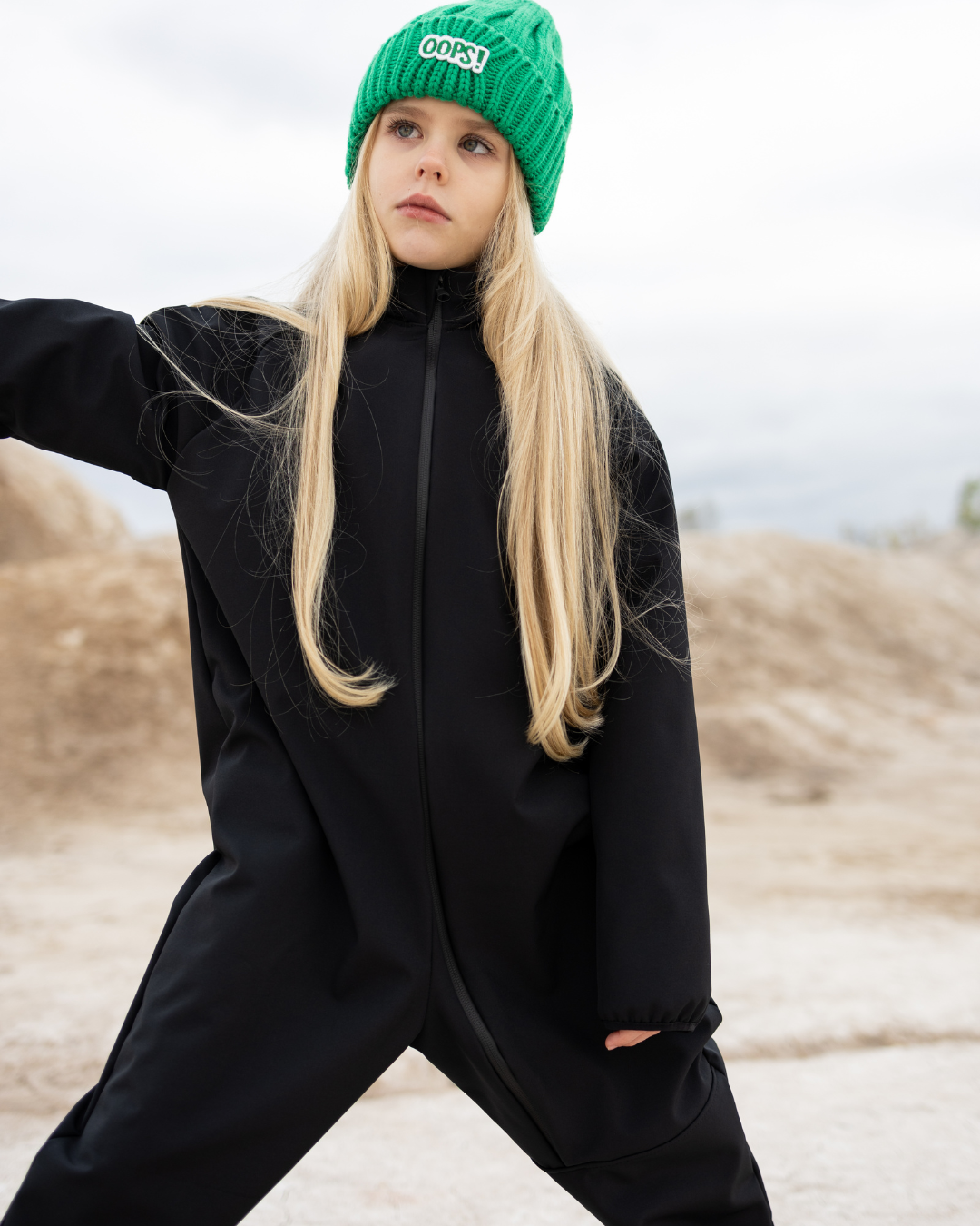 Girl wearing black softshell kids overall in outdoor setting