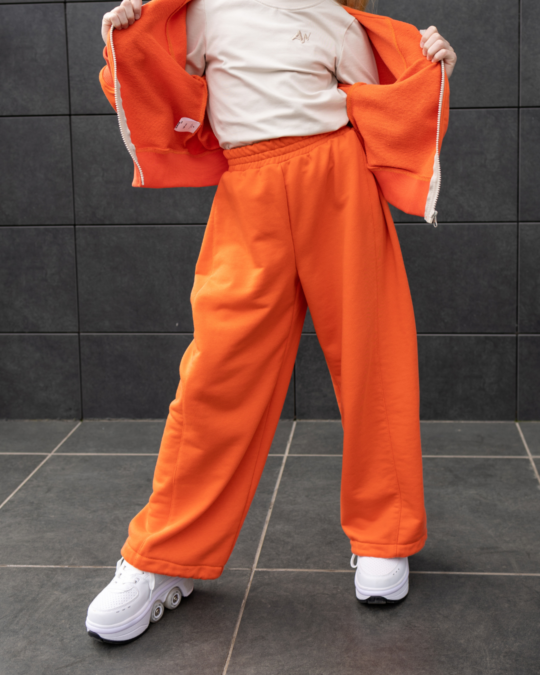 Alwair Kids orange oversize pants for girls front view with white sneakers