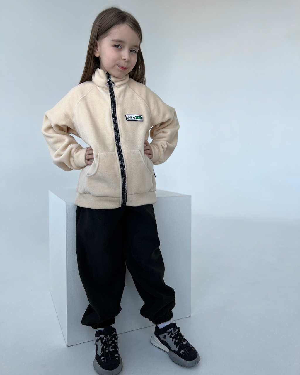 Happy girl wearing beige fleece mood zip jacket for kids by Alwair Kids