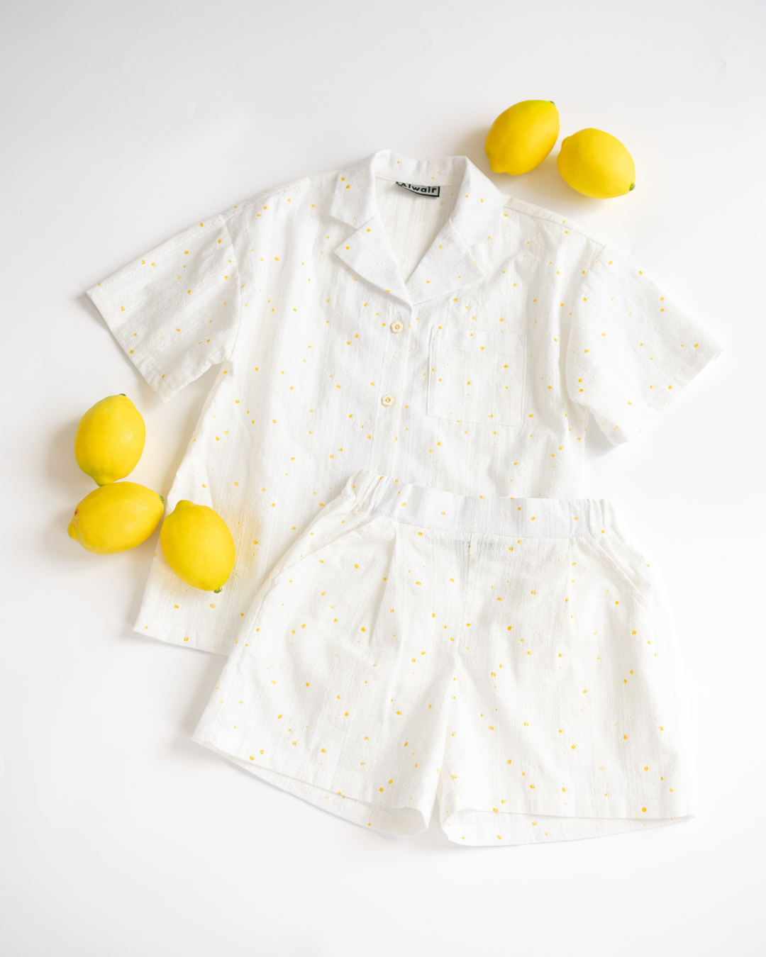 Summer girl set with flower print by Alwair Kids flatlay with lemons on white background

