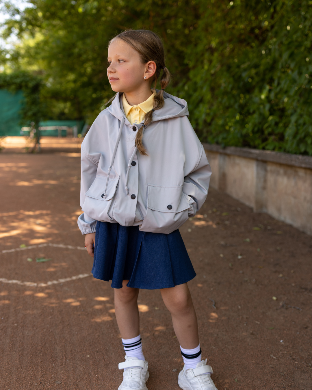 Girl wearing Alwair Kids grey windbreaker jacket on the playground