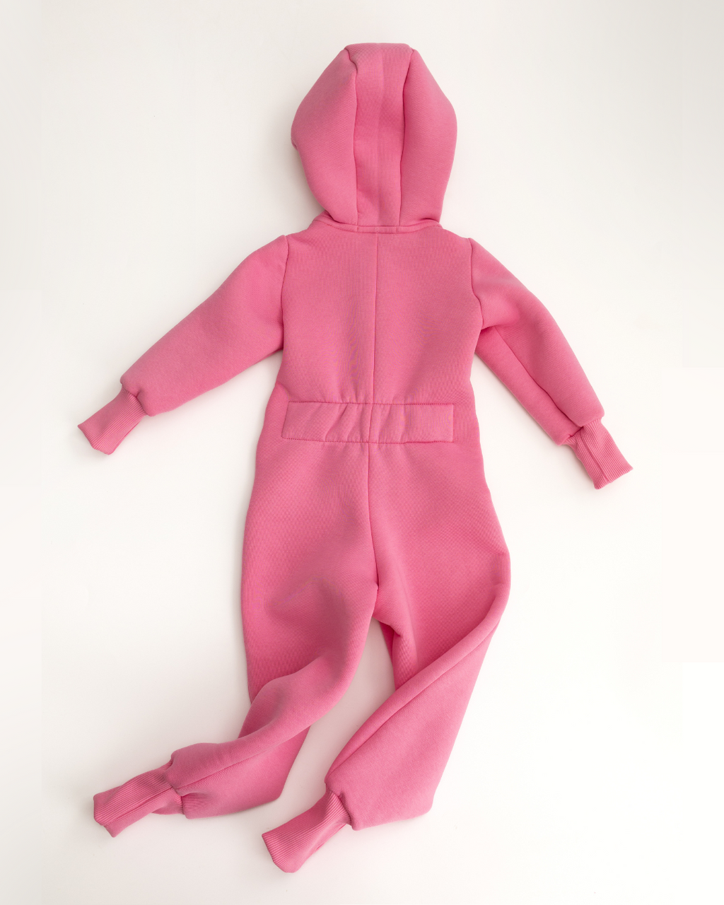 Back view of light pink fleece jumpsuit for kids with elastic waistband and hood