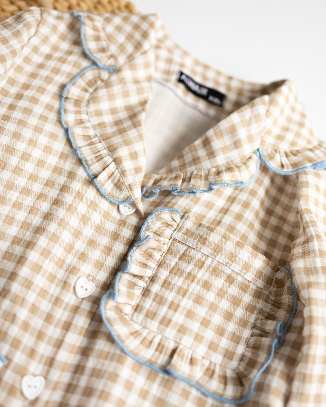 Close-up of ruffled collar and heart buttons on girls' muslin pajama top