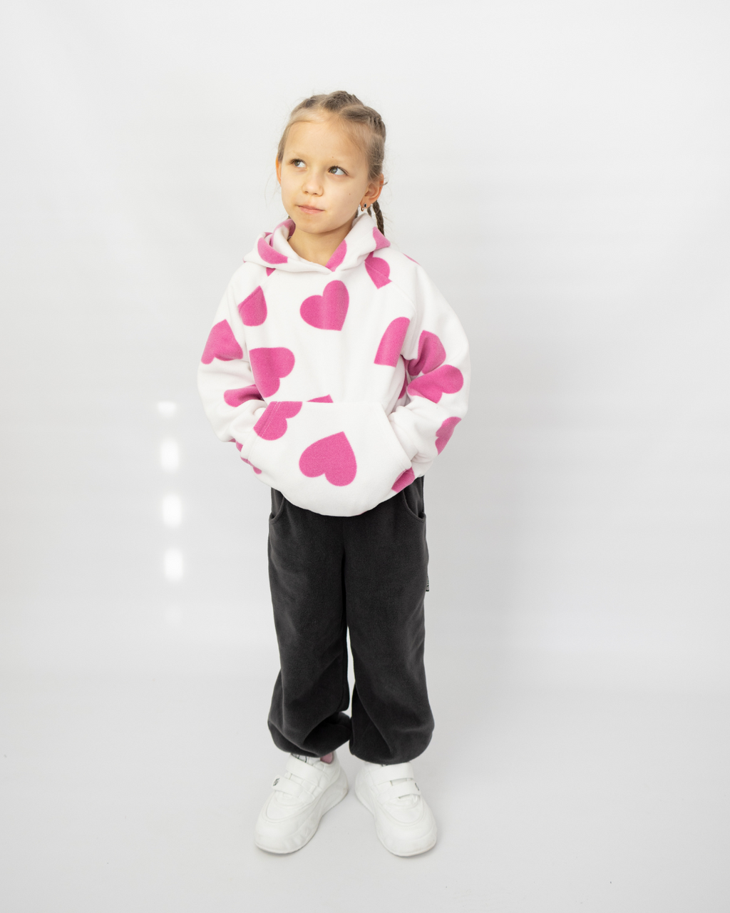 Girl wearing white fleece hoodie with pink hearts by Alwair Kids