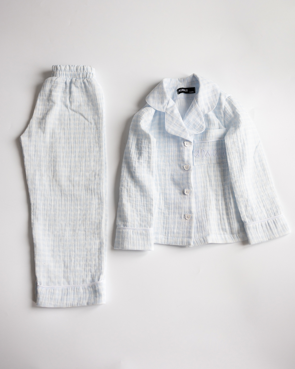 Light blue muslin girls’ pajama set – shirt and pants side by side on white background