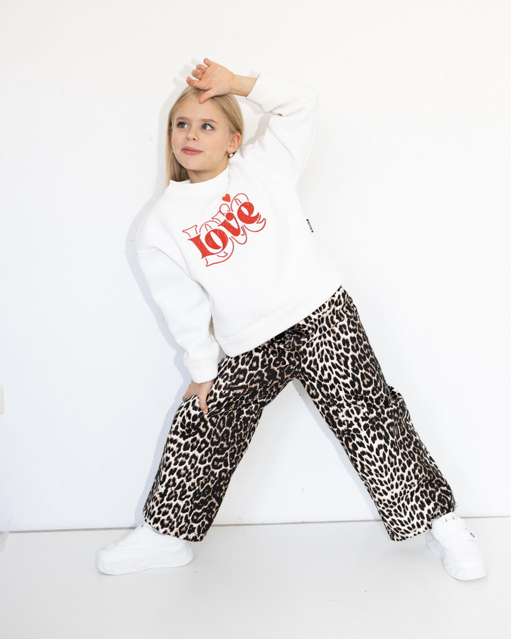 Girl wearing leopard print jeans from Alwair Kids in playful pose