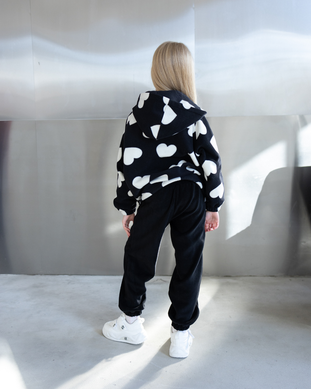 Back view of girl in fleece zip hoodie with white heart print by Alwair Kids