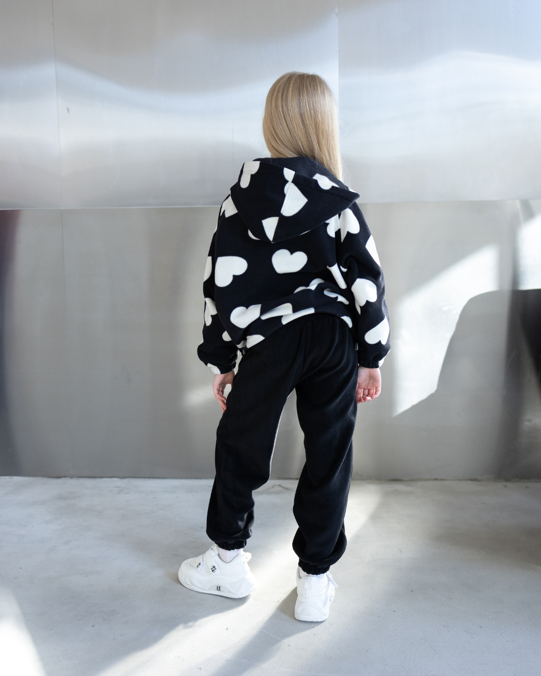 Back view of girl in fleece zip hoodie with white heart print by Alwair Kids
