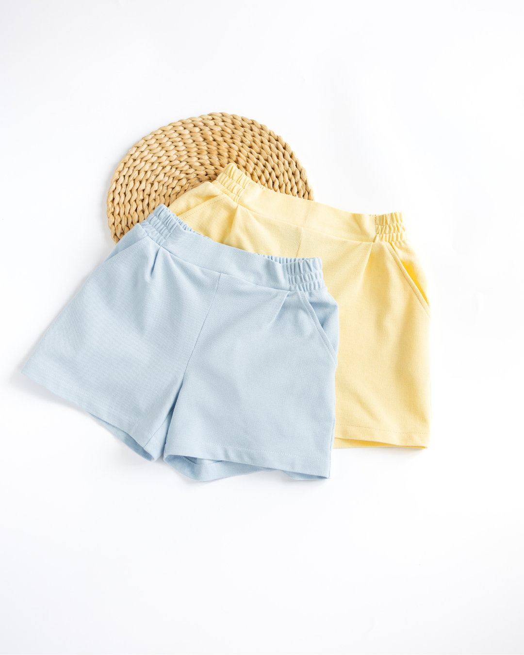 Blue and yellow lacoste summer shorts side by side for girls