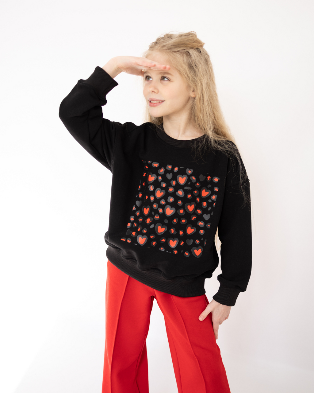 Girl wearing black sweatshirt with red heart pattern