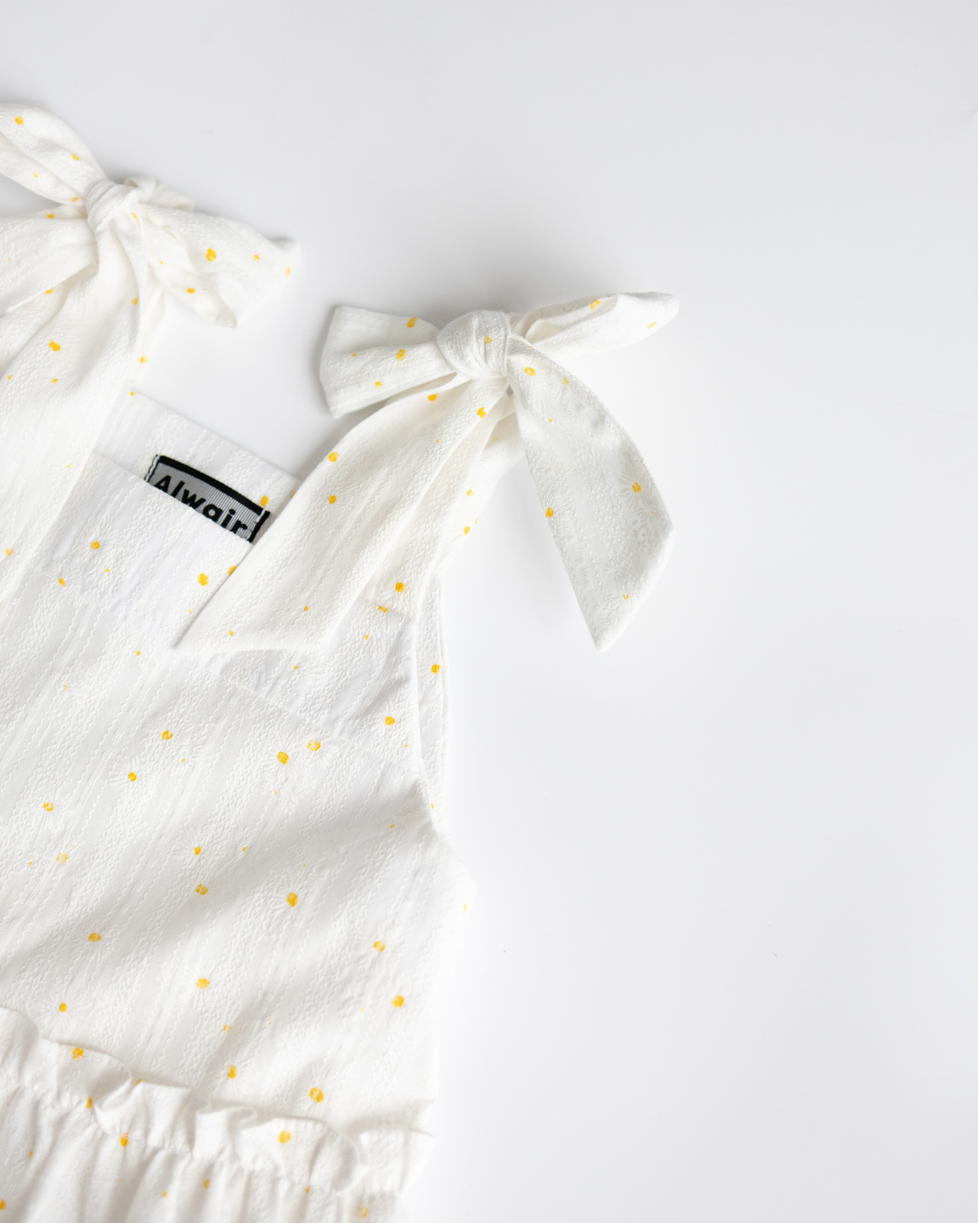 Close-up of shoulder ties on Alwair Kids white cotton dress
