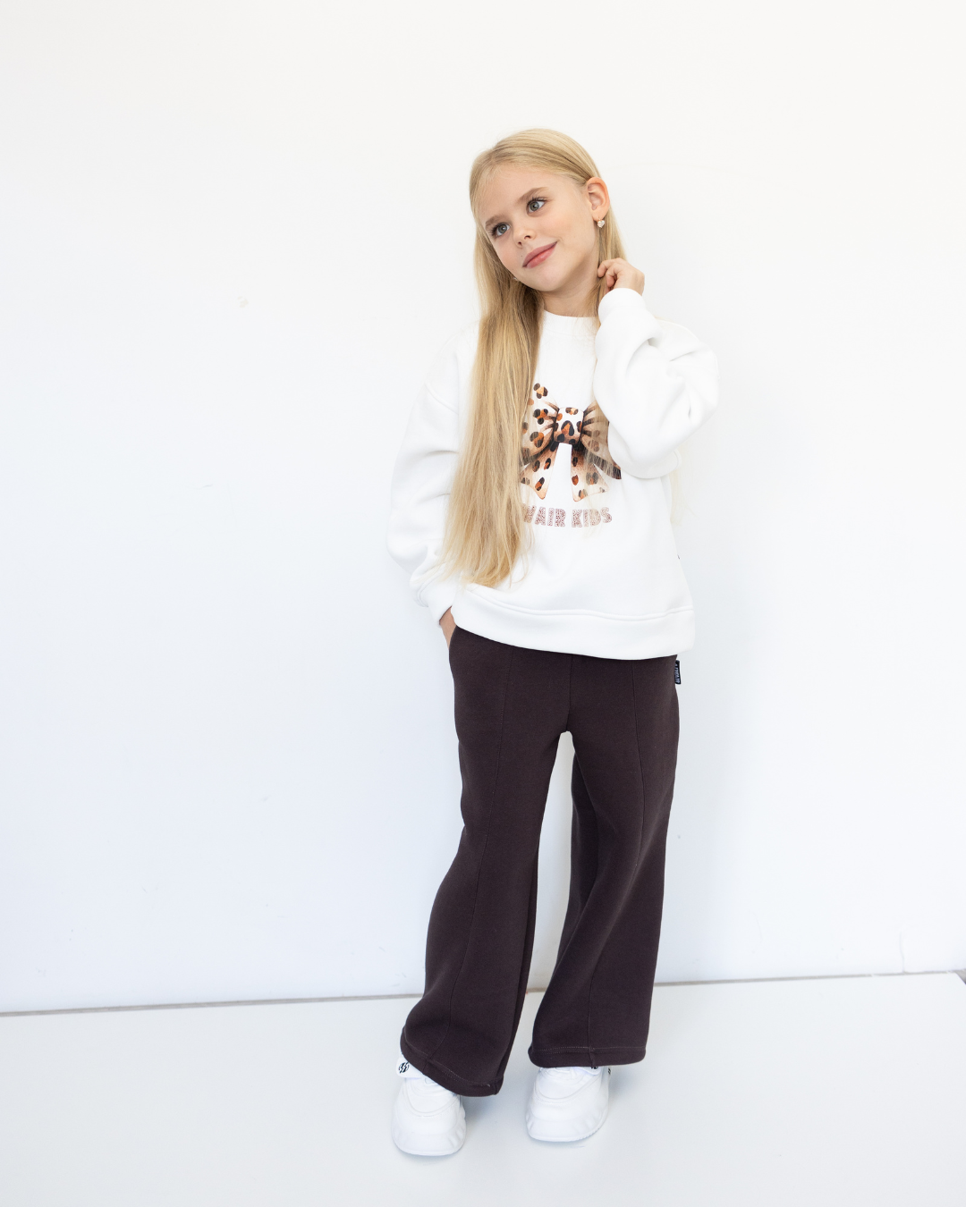 Fashionable brown kids pants Alwair Kids model posing playfully