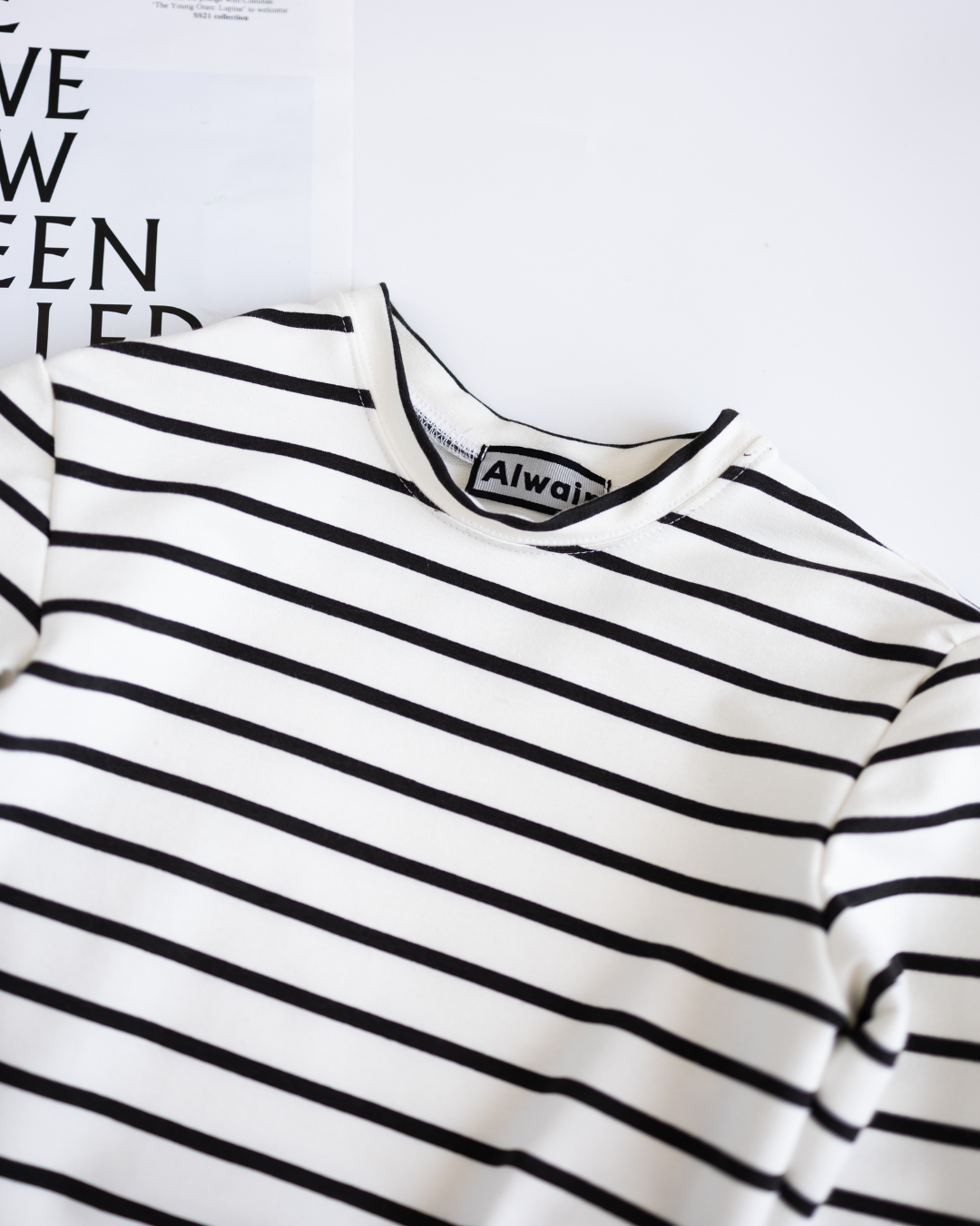 Close-up of neckline and label on striped cotton long sleeve Alwair Kids