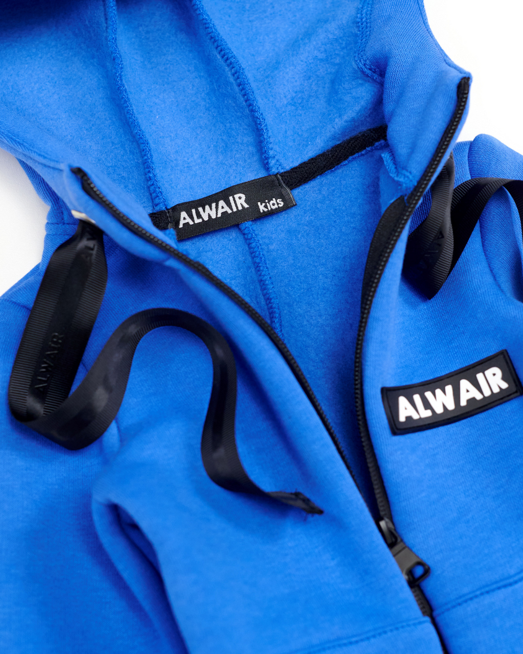 Close-up of zipper, Alwair logo and hood interior on sky blue fleece kids jumpsuit