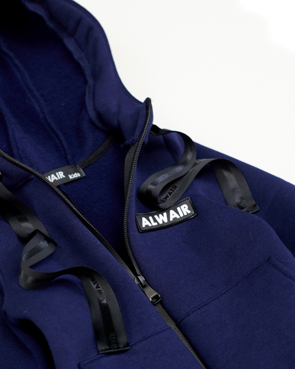 Close-up of zipper, logo and hood interior on navy blue fleece kids jumpsuit