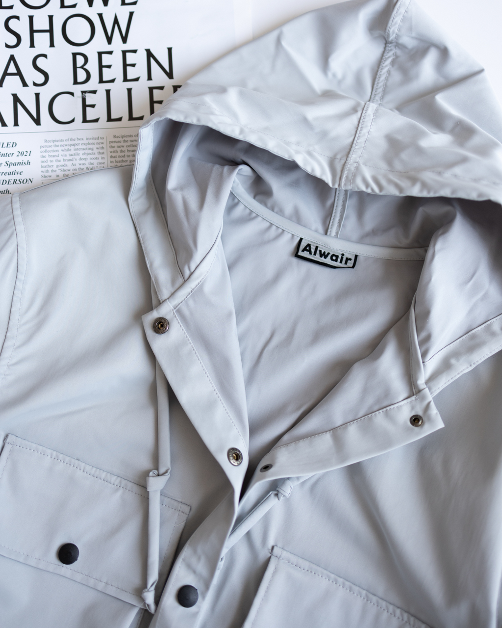 Close-up of hood and snap buttons on grey windbreaker jacket