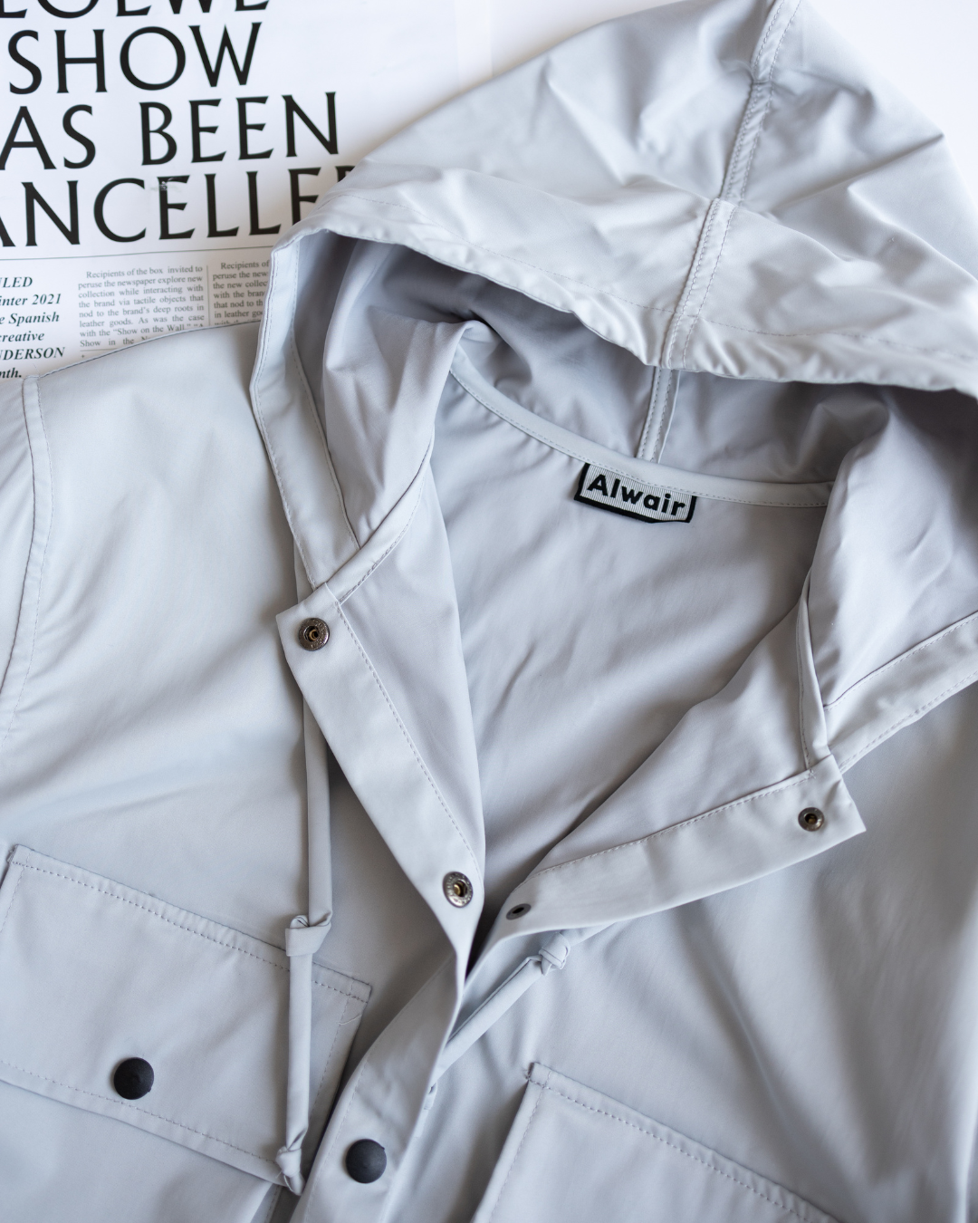 Close-up of hood and snap buttons on grey windbreaker jacket