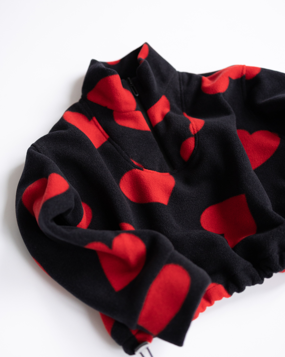 Side angle view of red heart girls fleece pullover with high collar


