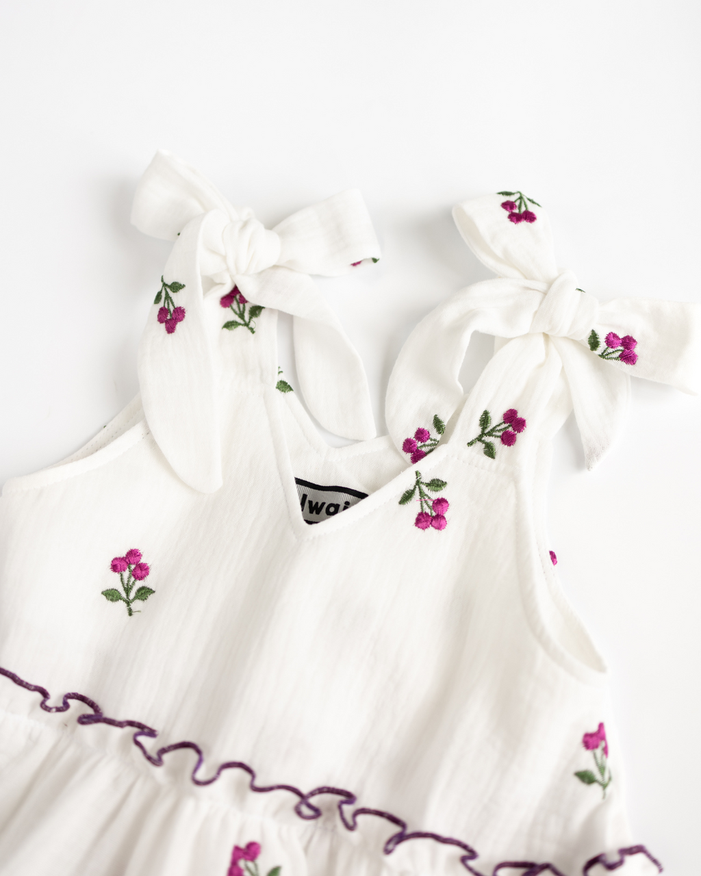 Close-up of tie shoulder straps with floral embroidery on girls muslin sundress – Alwair Kids

