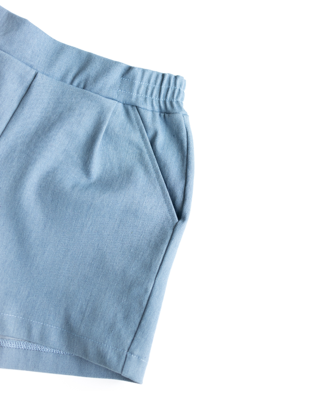 Close-up of elastic waistband and pockets on denim shorts