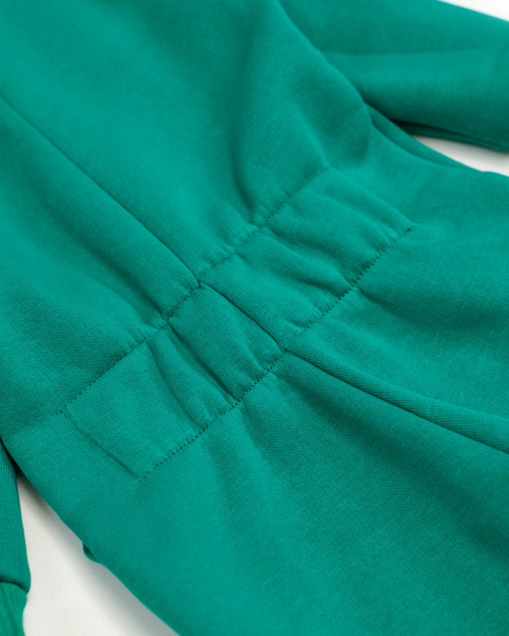 Elastic back detail on green fleece kids jumpsuit showing adjustable fit