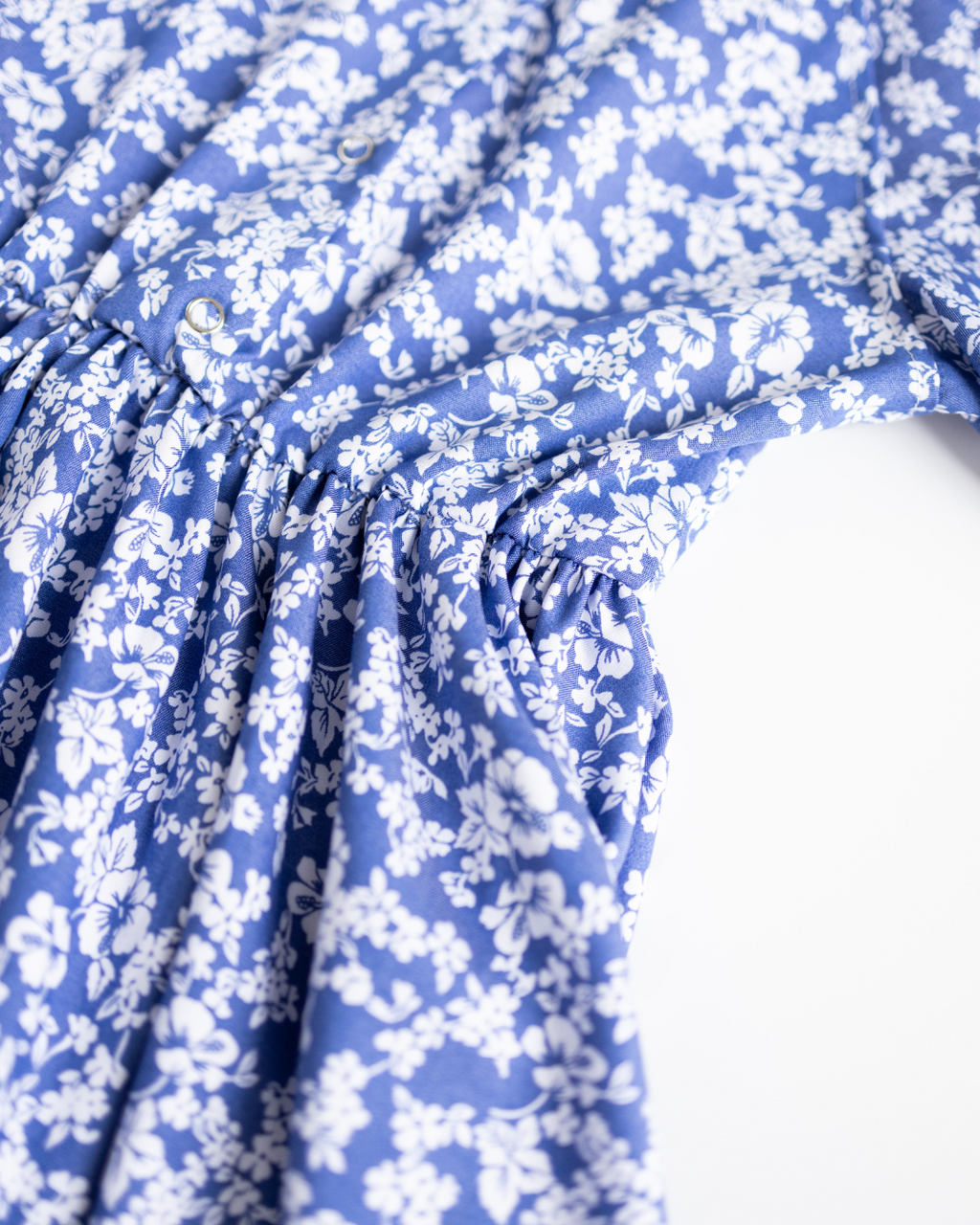 Close-up of front buttons and elastic waist of girls summer dress in floral tencel fabric