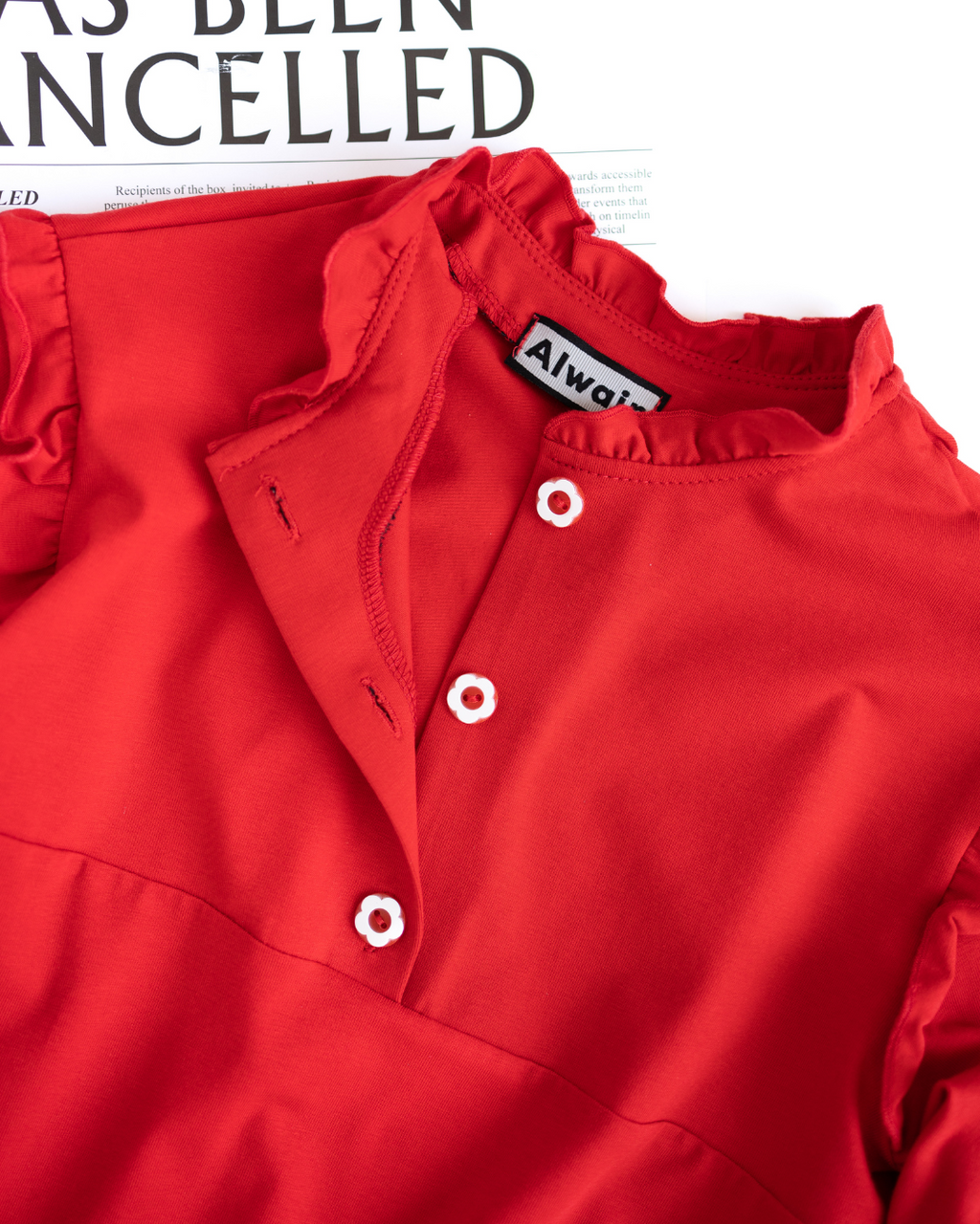 Close-up of floral buttons and neckline of red girls top by Alwair Kids