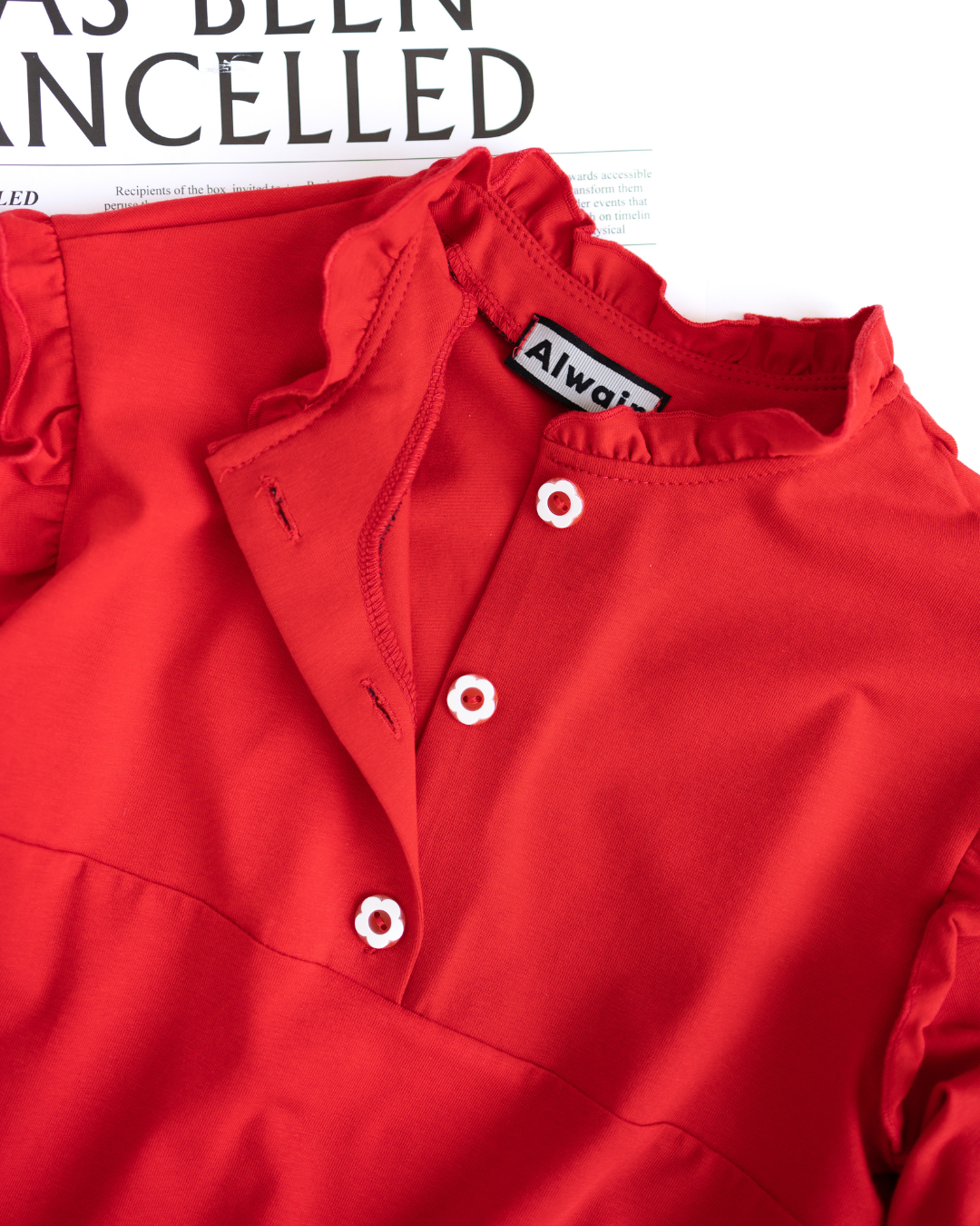 Close-up of floral buttons and neckline of red girls top by Alwair Kids