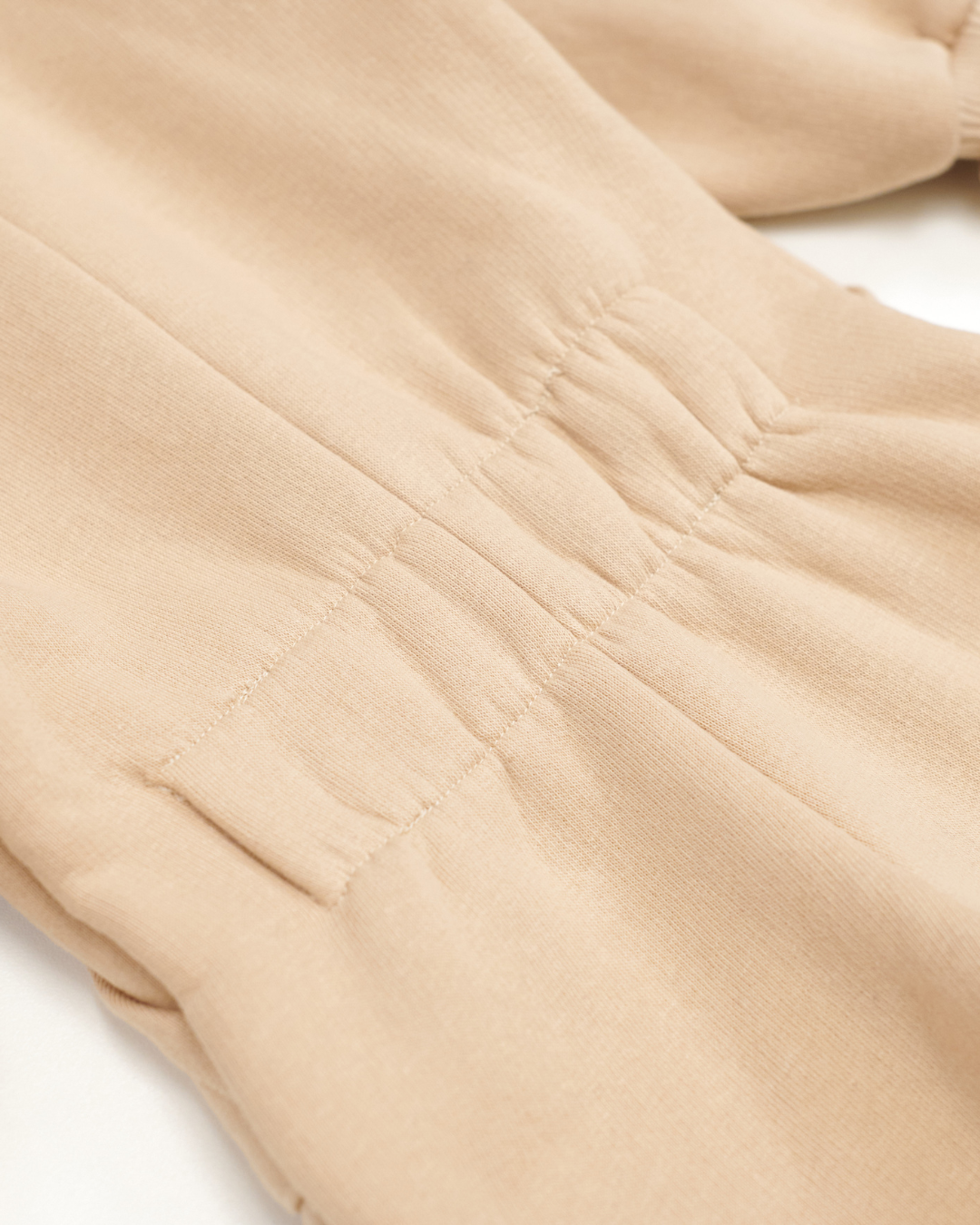 Detail of elastic back waistband on kids beige fleece jumpsuit