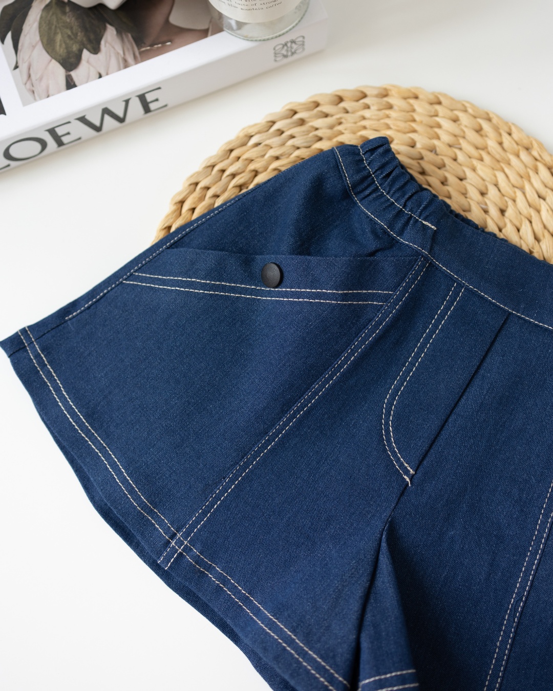 Close-up of elastic waistband and detailed stitching on girls denim shorts