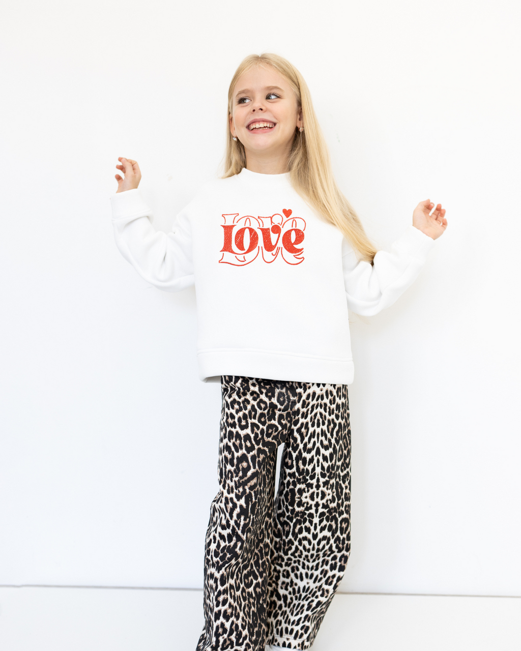 Stylish white sweatshirt with Love print shown in playful pose