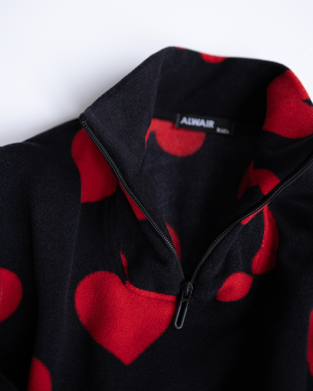 Close-up of red heart fleece girls pullover collar and zip detail