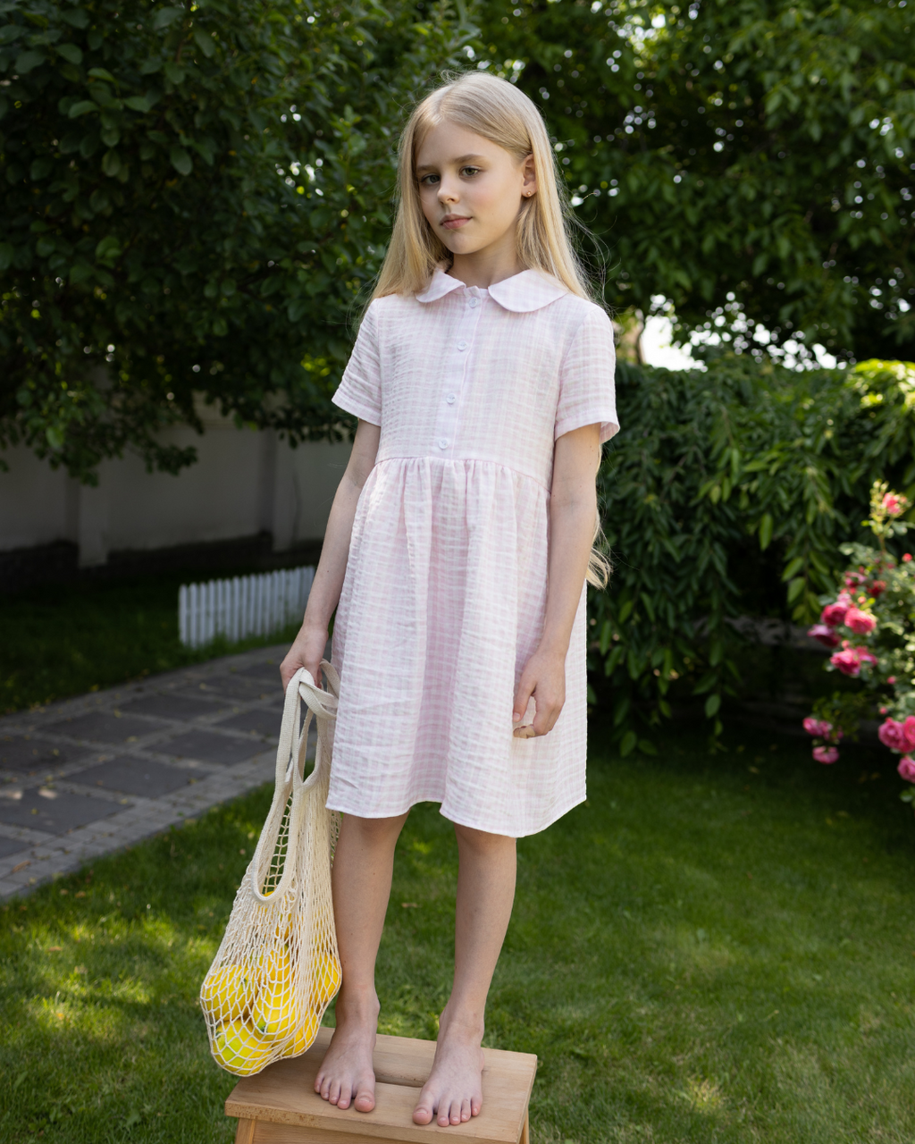 Girl in a light pink muslin dress by Alwair Kids – classic Peter Pan collar, short sleeves, and soft texture for gentle summer days