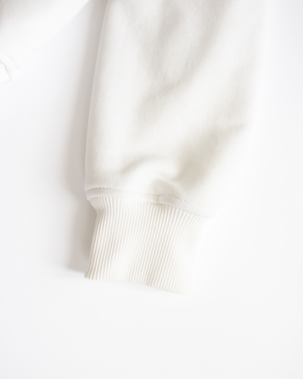 Close-up of sleeve cuff on white kids tennis sweatshirt