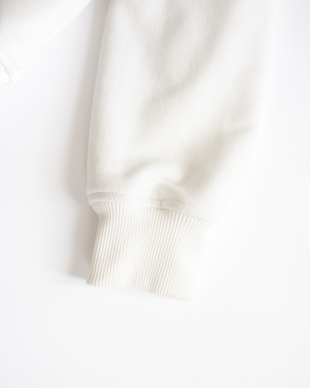 Close-up of sleeve cuff on white kids tennis sweatshirt