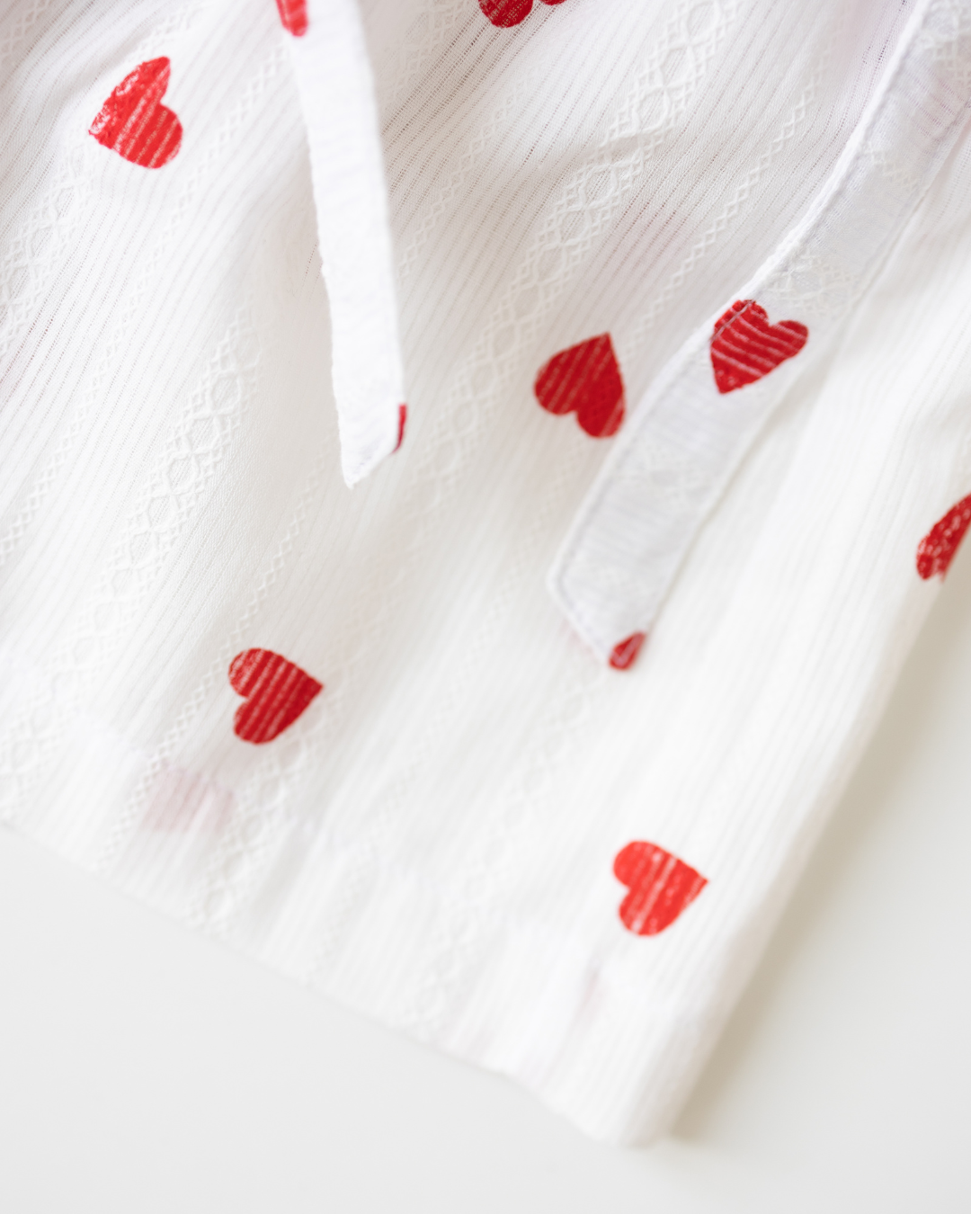 Detail shot of soft batiste fabric with red heart pattern on girls' summer skort – Alwair Kids


