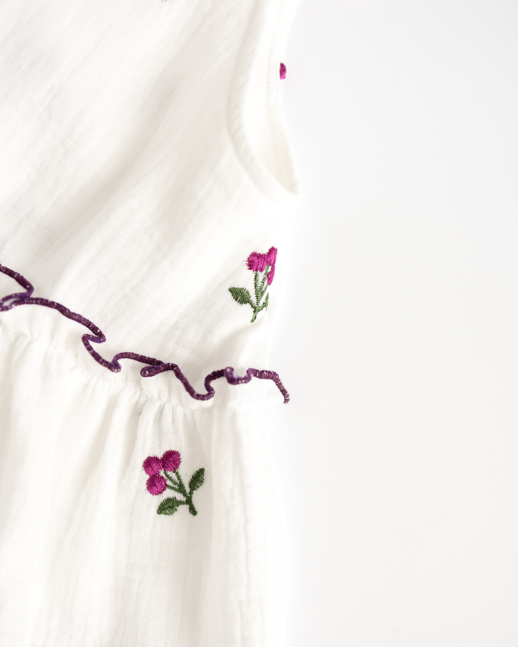 Detail view of embroidered flower and ruffle stitching on white muslin girls dress – Alwair Kids