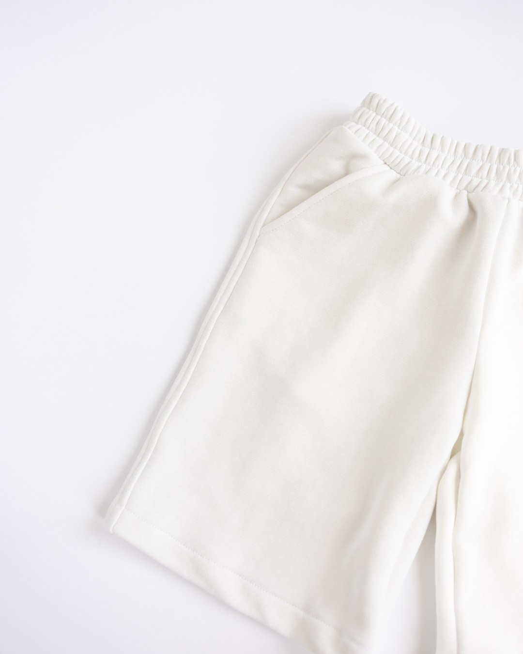 Close-up of side pocket and stitching on white boys shorts Alwair Kids