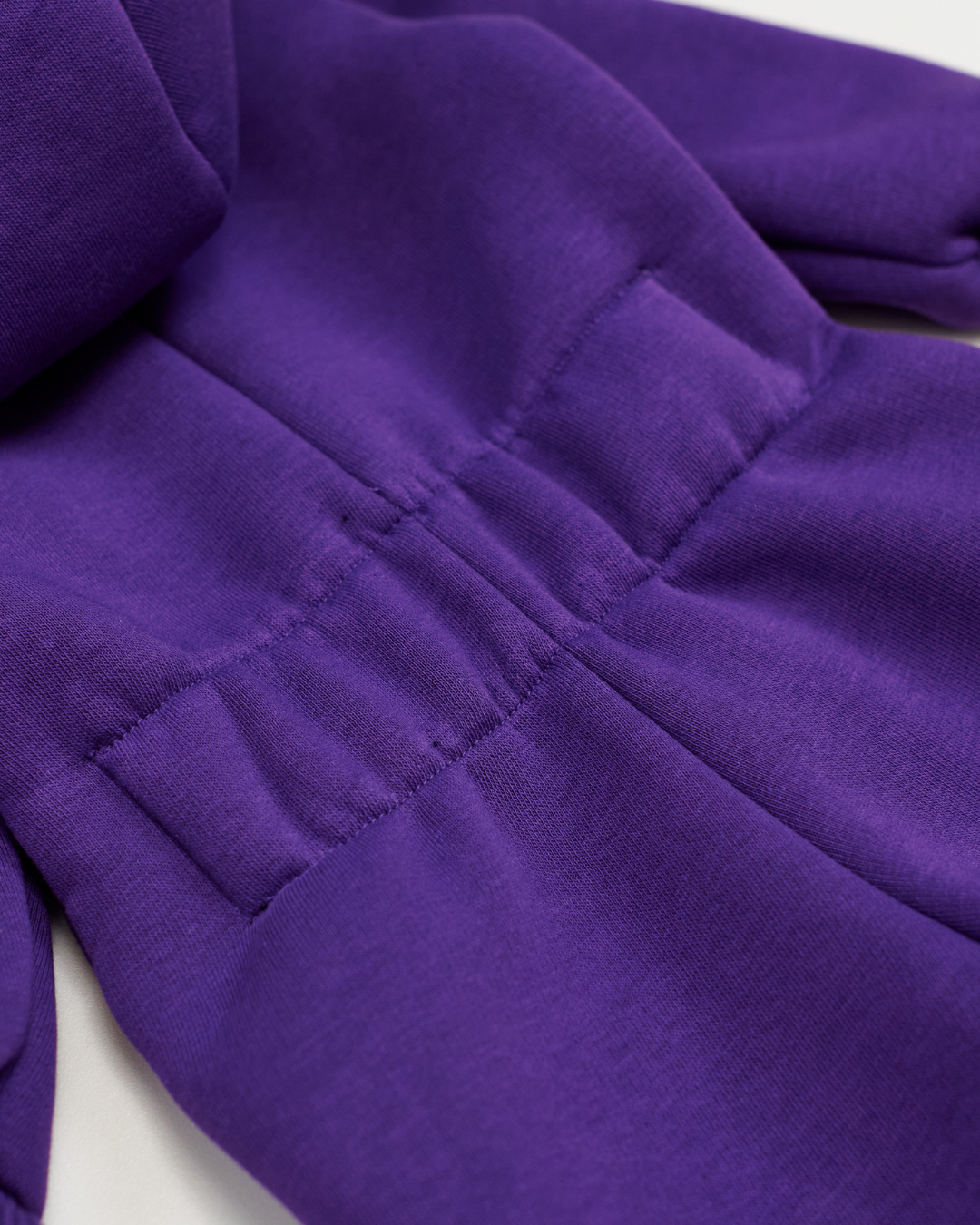 Elastic back detail on purple fleece kids jumpsuit showing stretch feature