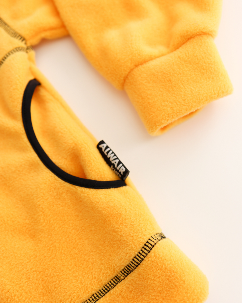 Brand tag and contrasting seam details on kids fleece top by Alwair Kids