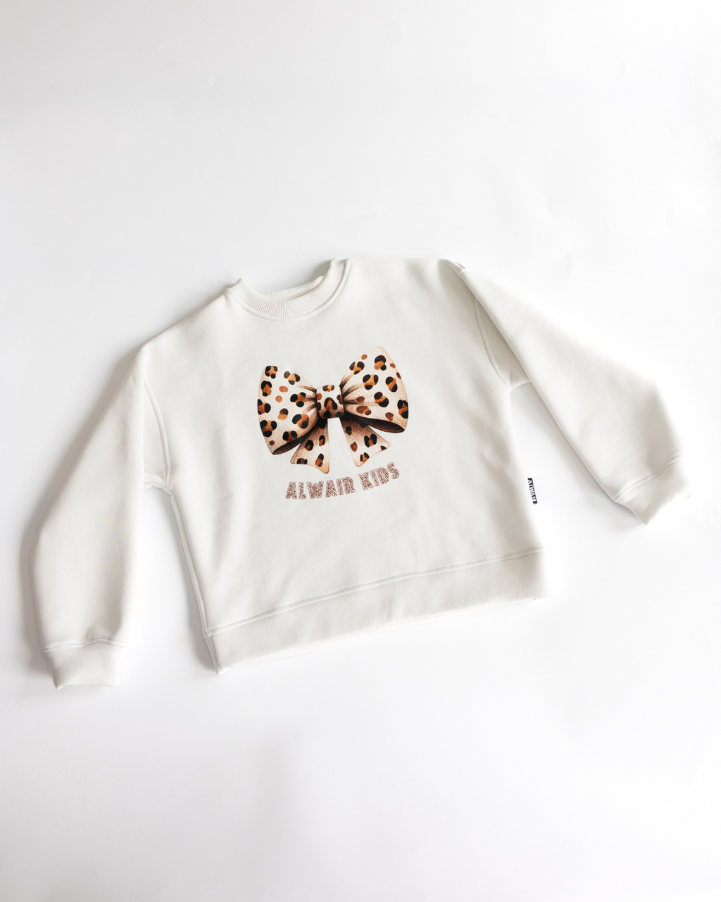 Flat lay of white sweatshirt with leopard bow print Alwair Kids