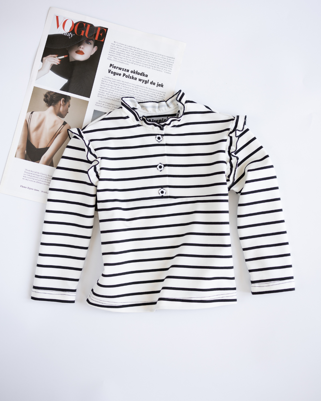 Striped girl cotton longsleeve with ruffles by Alwair Kids flat lay front view with magazine
