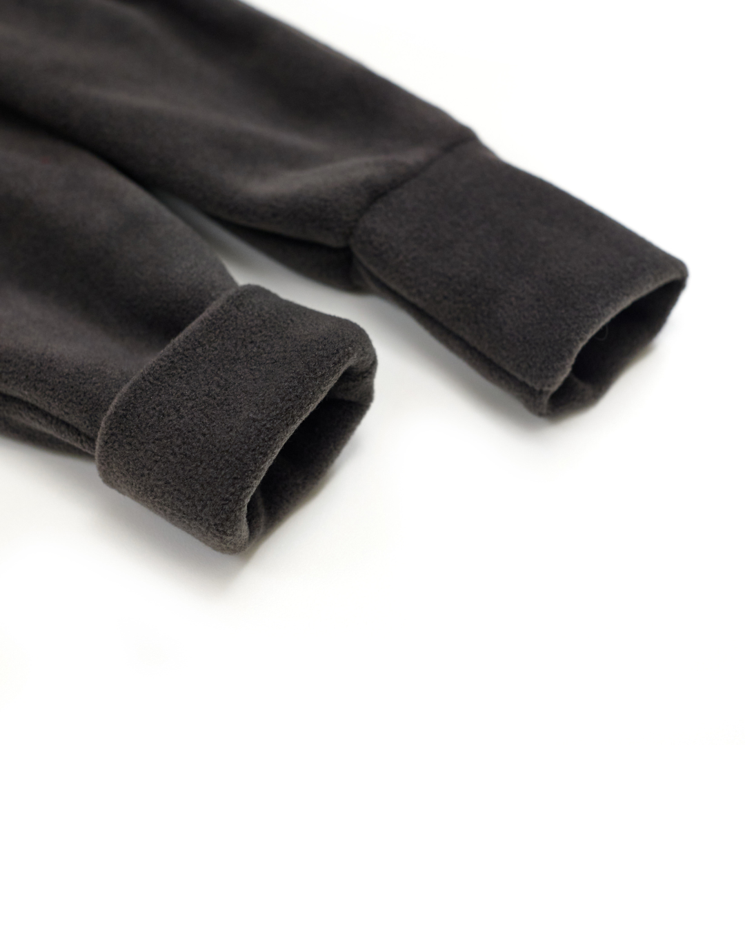 Folded fleece cuffs on charcoal kids jumpsuit – close-up texture
