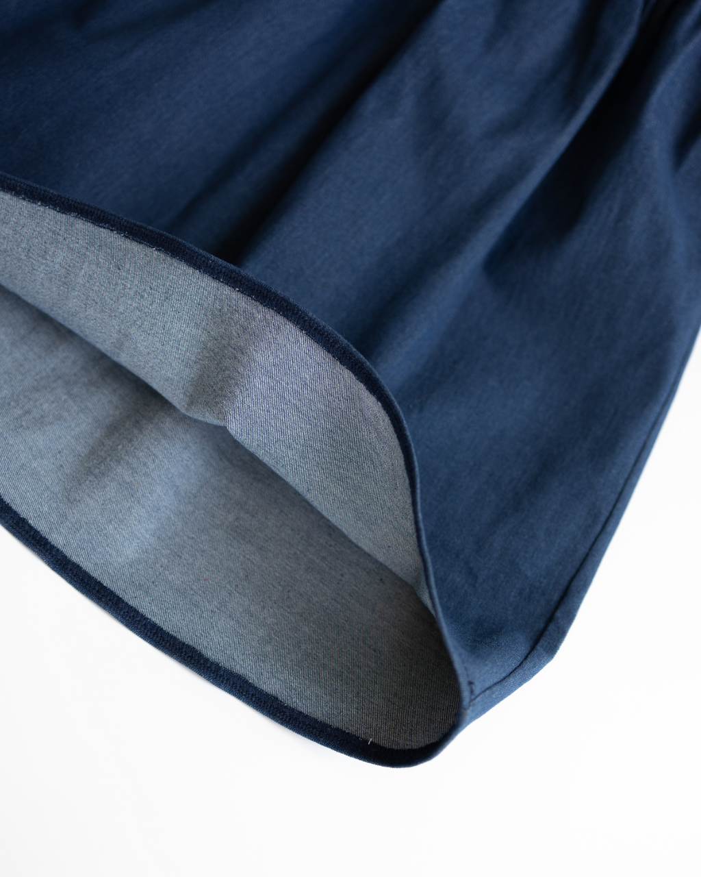 Close-up of hem and interior stitching of denim tennis dress for kids