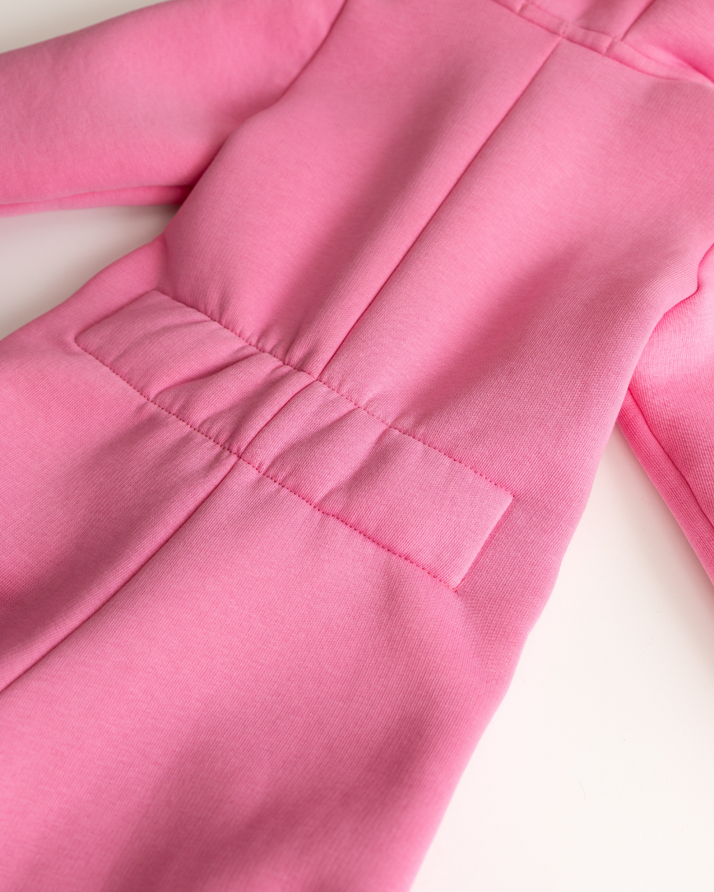 Elastic back waistband detail on light pink fleece jumpsuit for children